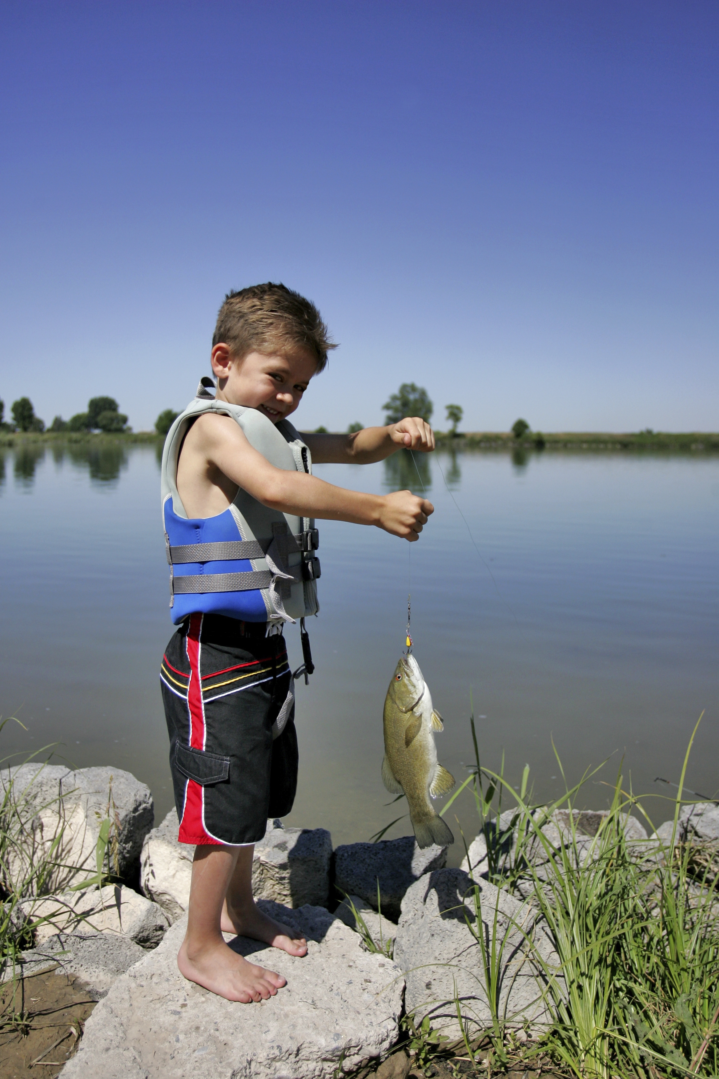 Young boy holding fish 